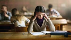 Female university student studying hard in library
