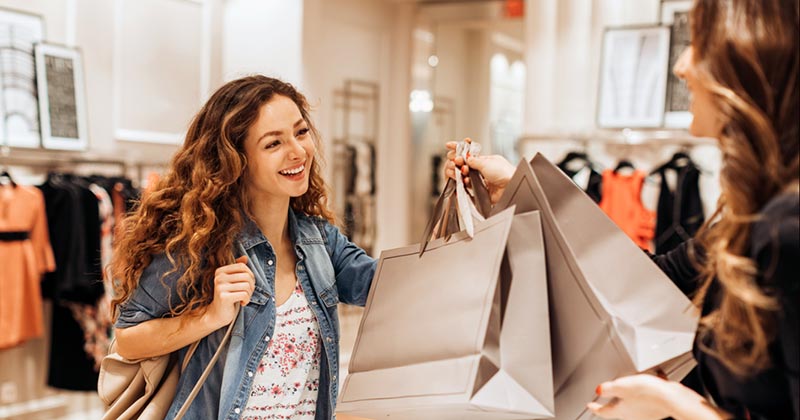 Smiling woman at holding shopping bags