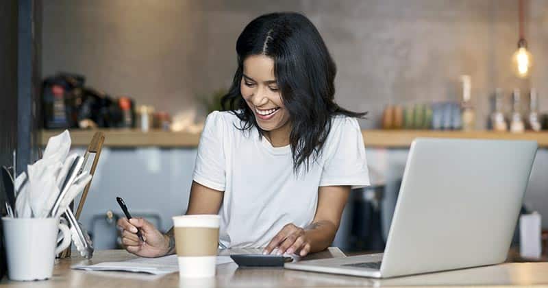 Woman smiling while writing notes